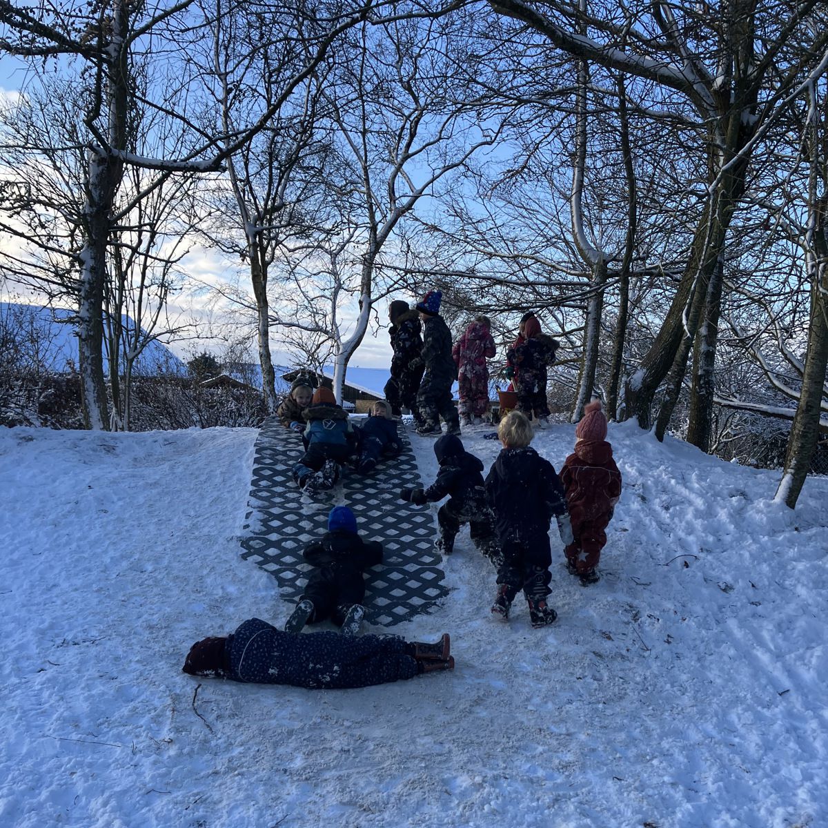 Børn leger i sne i Børnehuset Svalereden