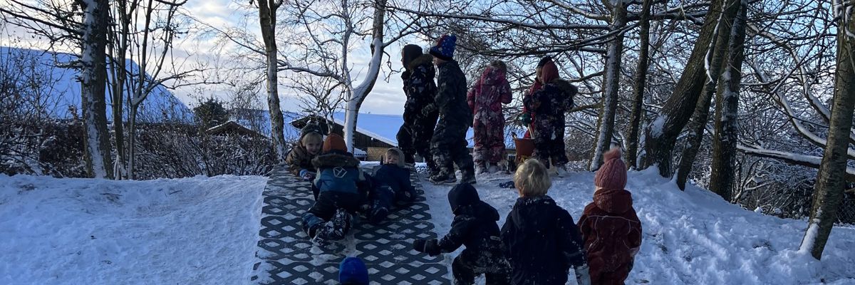 Børn leger i sne i Børnehuset Svalereden