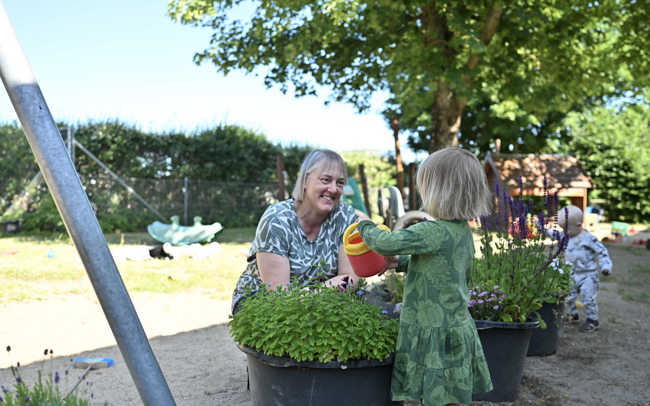 Barn og voksen vander planter