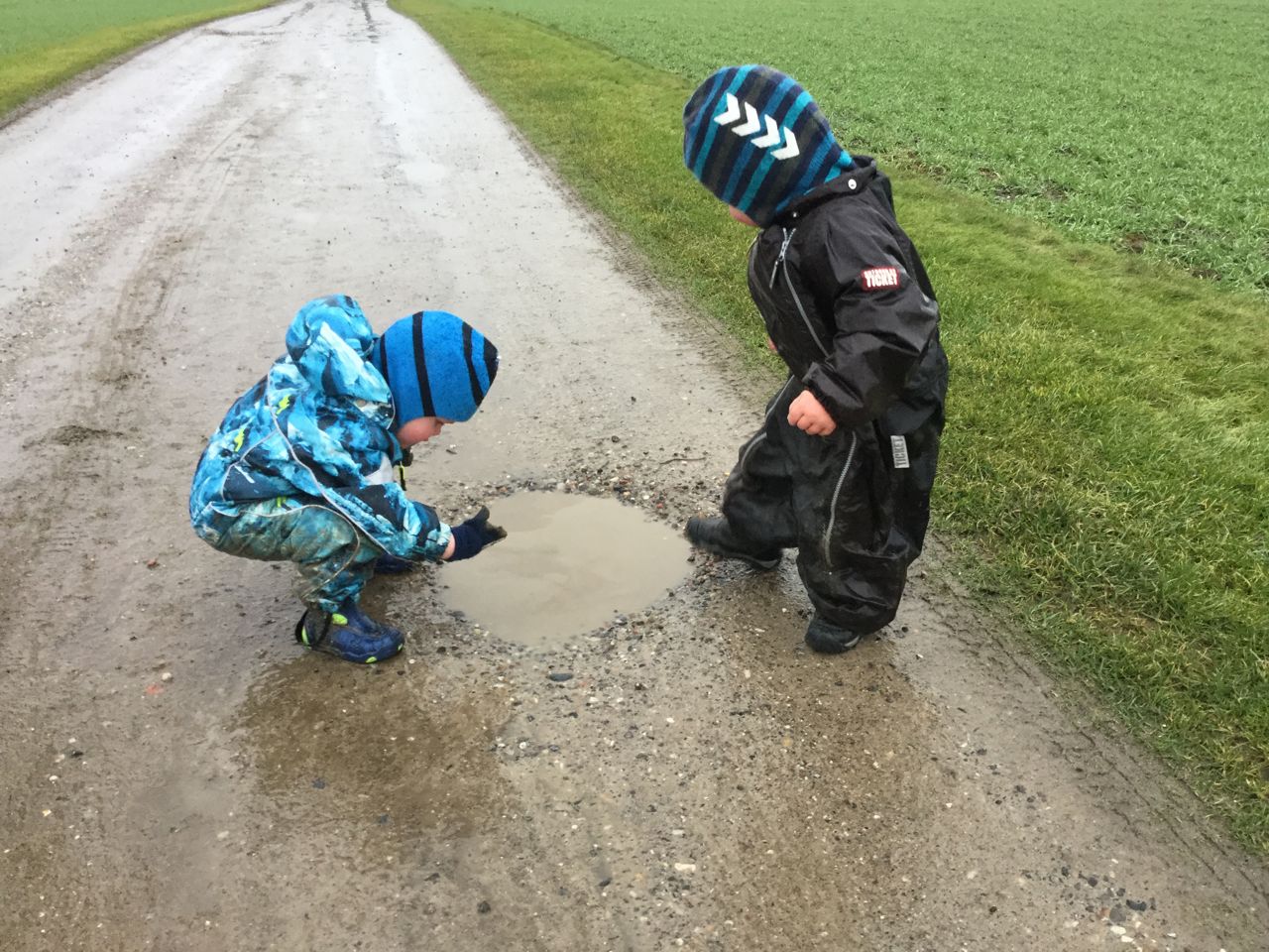 Børn leger ved vandpyt i Børnehuset Svalereden