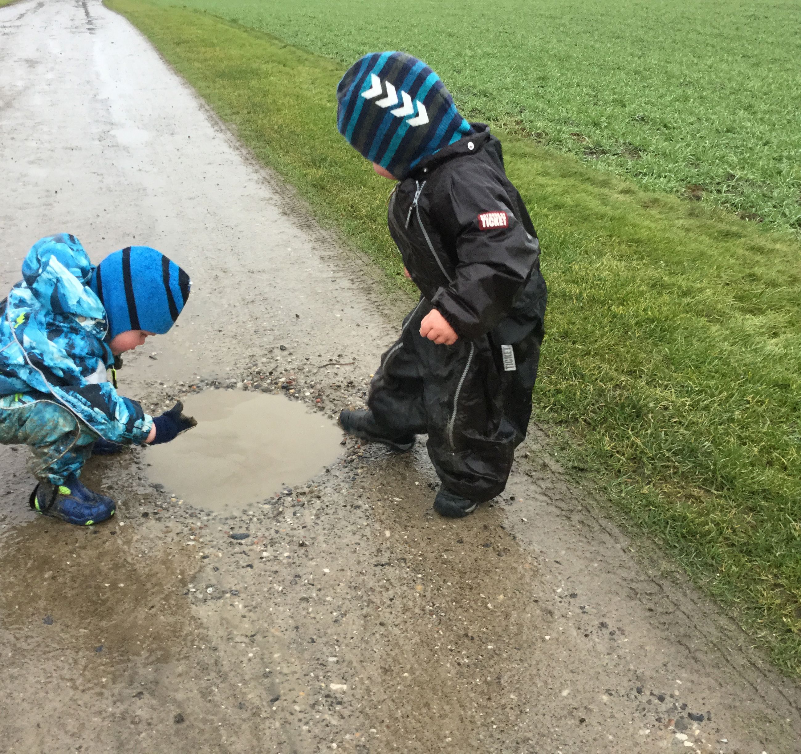 Børn leger ved vandpyt i Børnehuset Svalereden