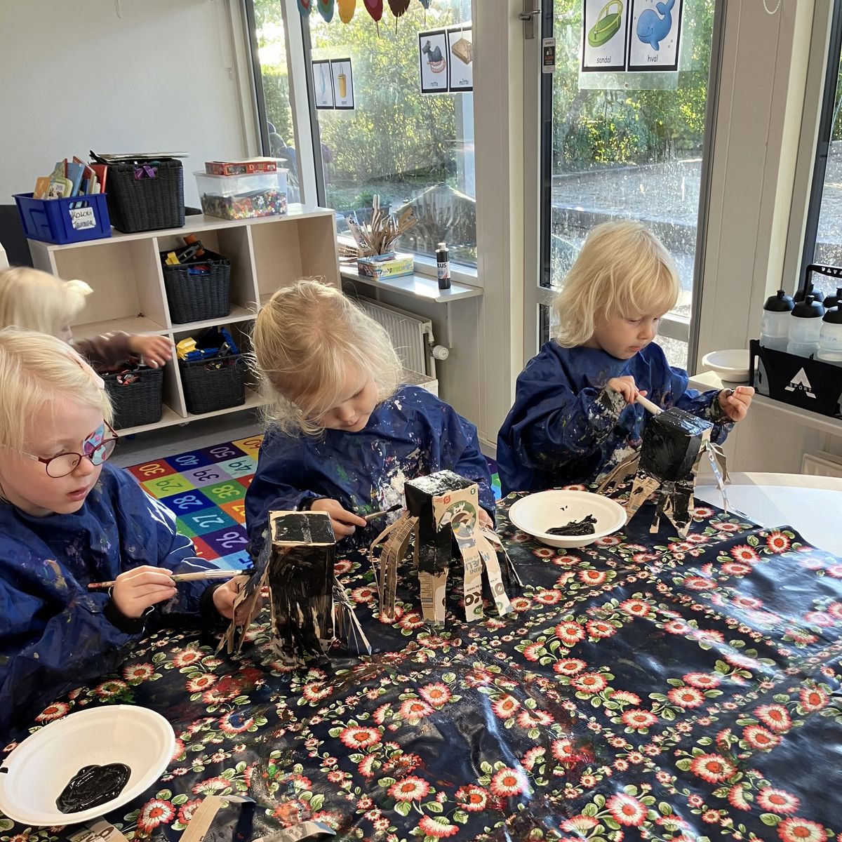 Børn maler mælkekartoner i Børnehuset Svalereden