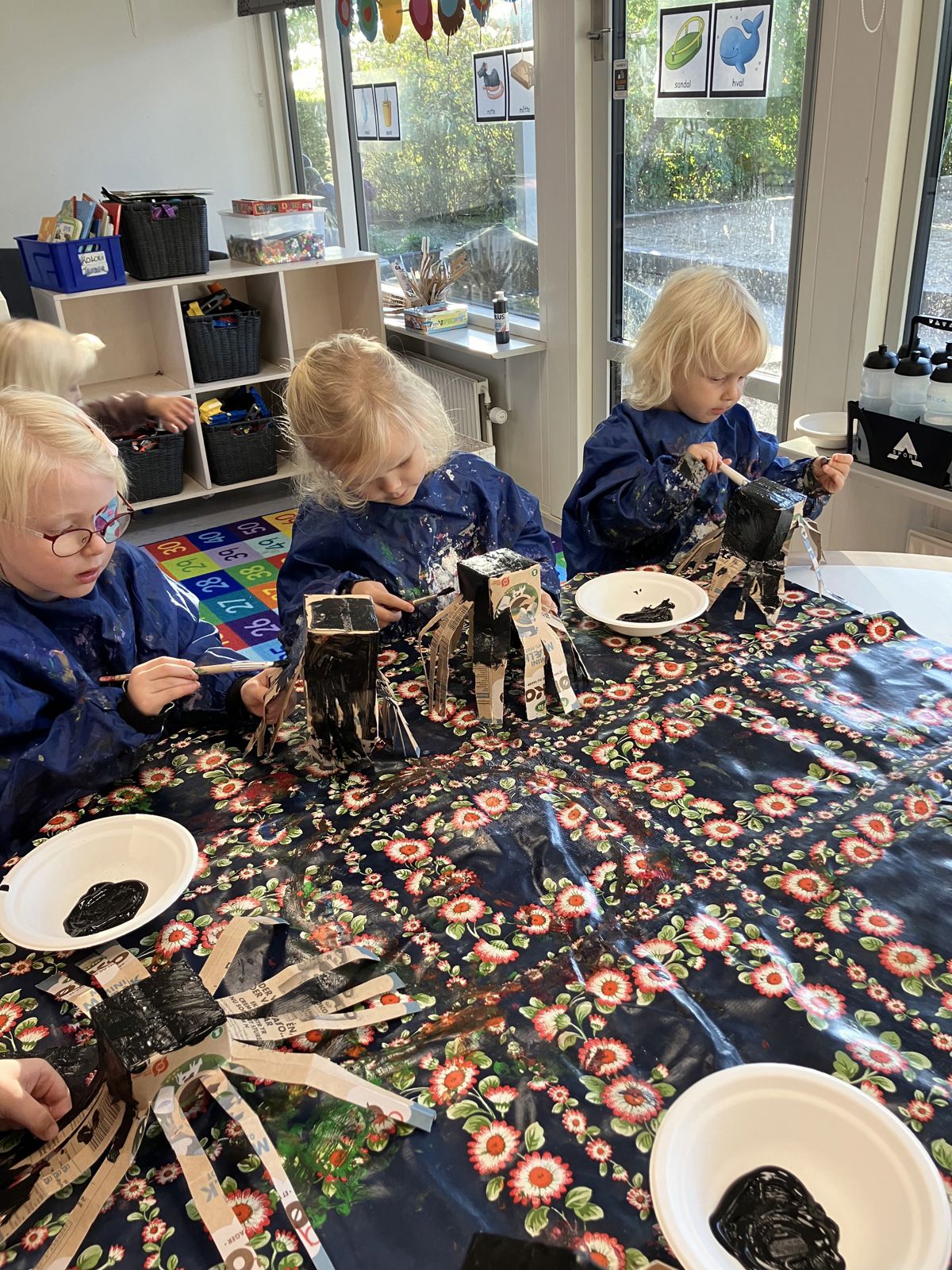 Børn maler mælkekartoner i Børnehuset Svalereden