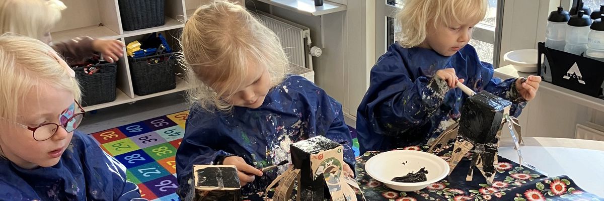 Børn maler mælkekartoner i Børnehuset Svalereden