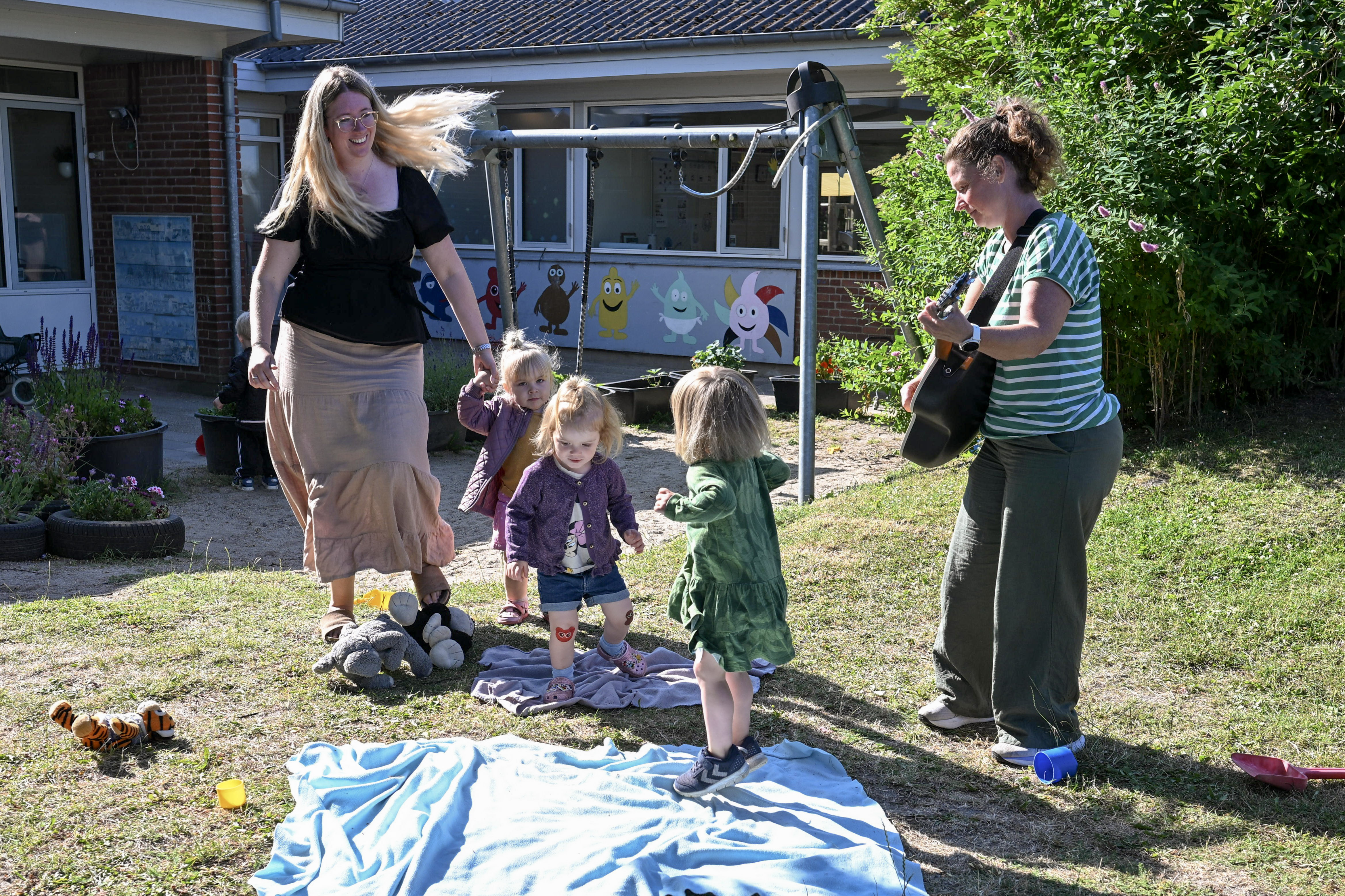 Børn og voksne danser og spiller guitar